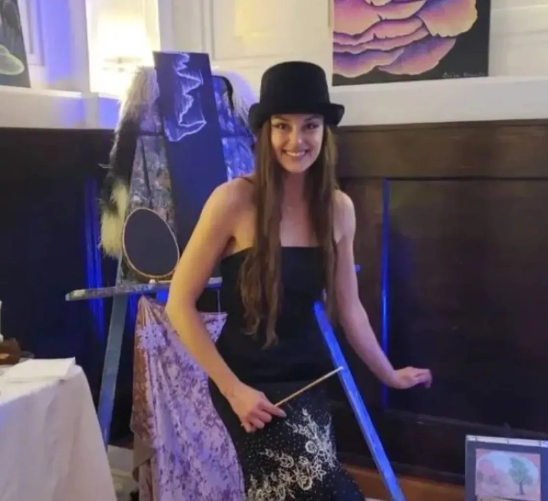Irisa Kennedy with her paintbrush and artwork