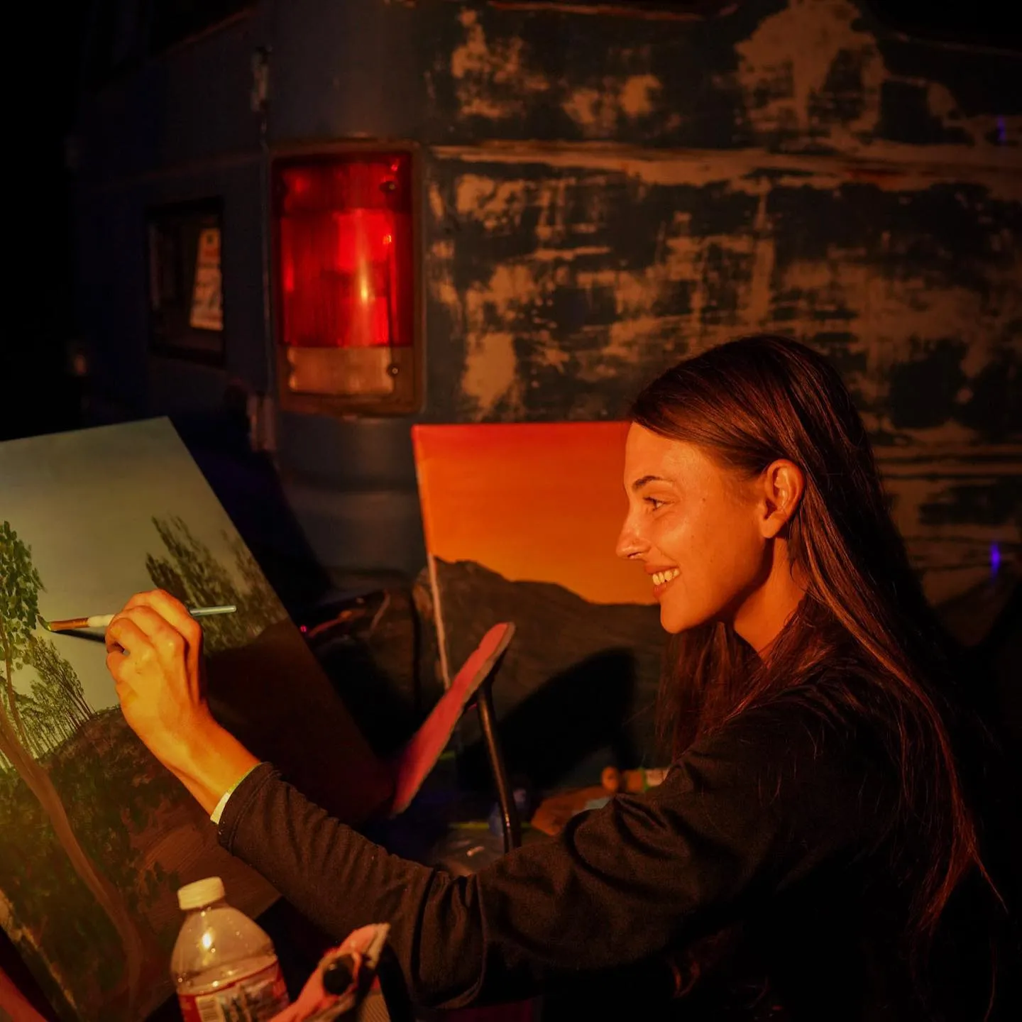 Irisa smiling while painting live at an easel