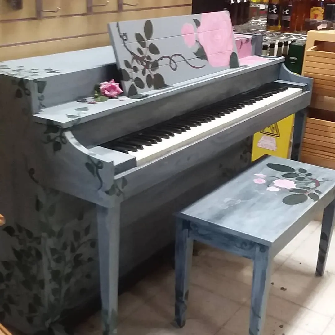 A piano and bench painted with flowers
